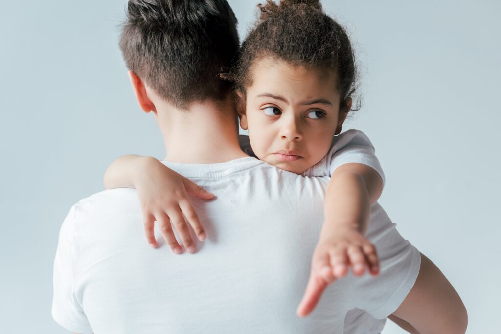 Foster father walking away with a sad child after termination of parental rights